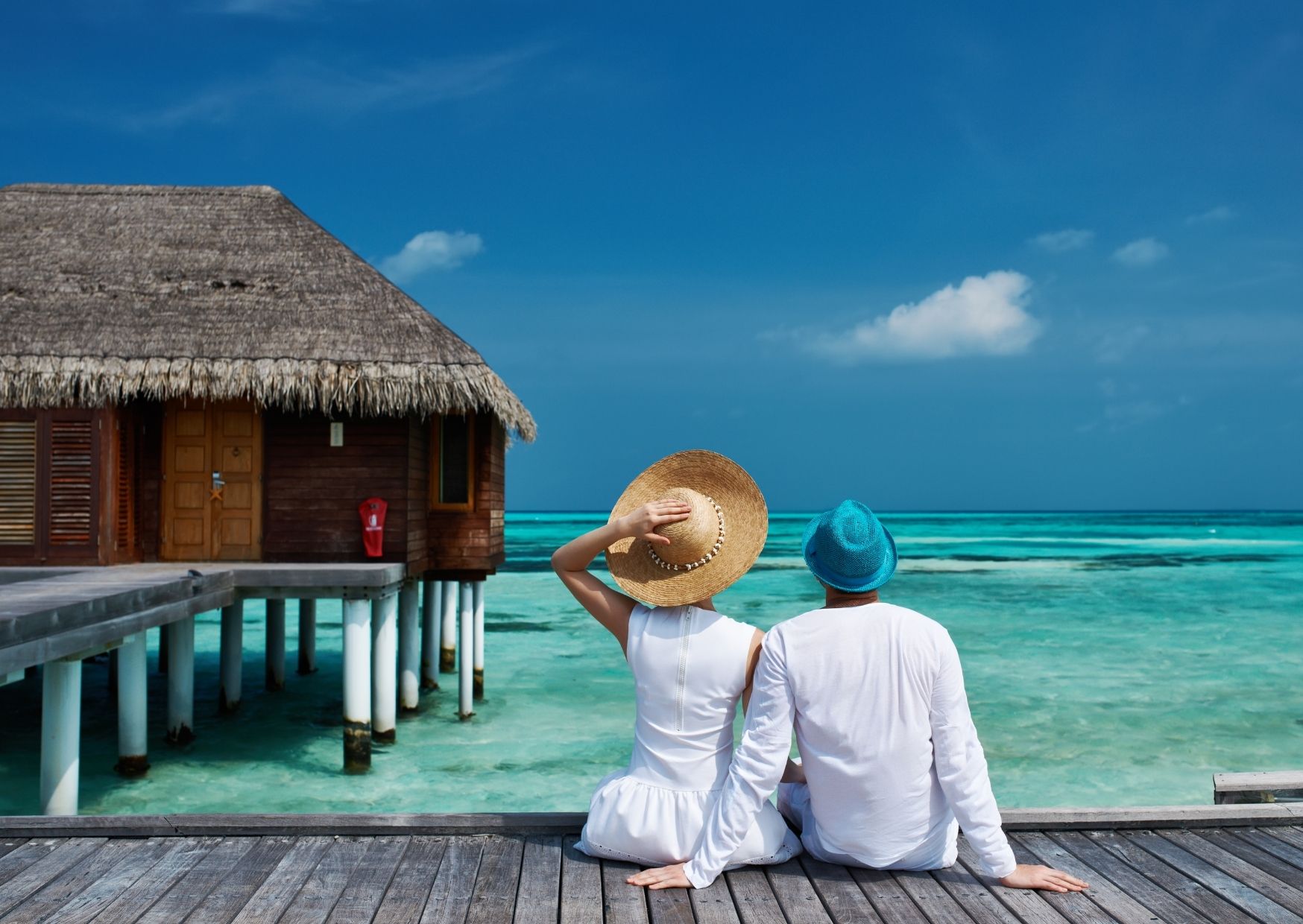 Couple Sitting by Overwater Villa in Maldives